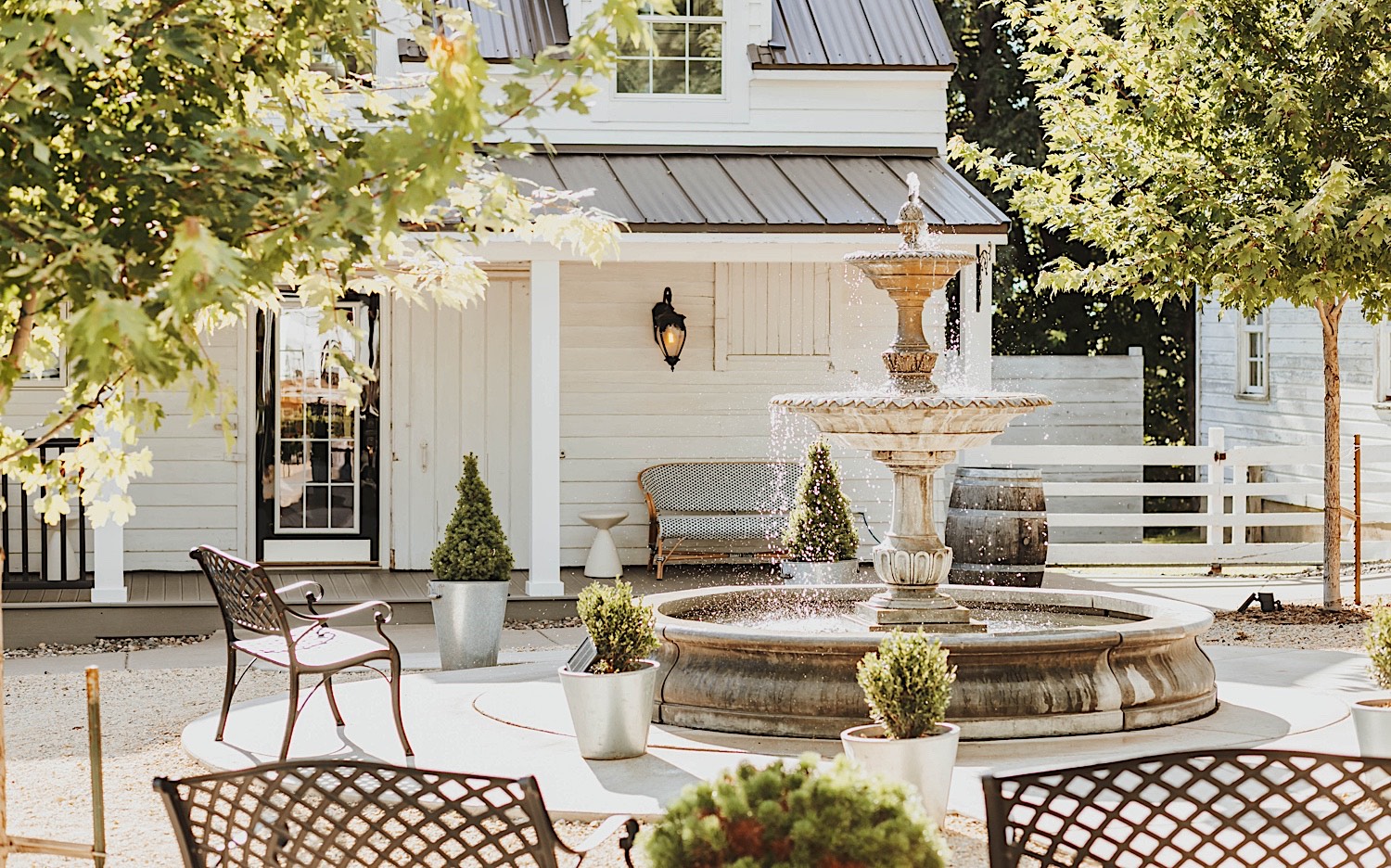 A fountain outside of a white building on the grounds of the wedding venue Legacy Hill Farm in Minnesota